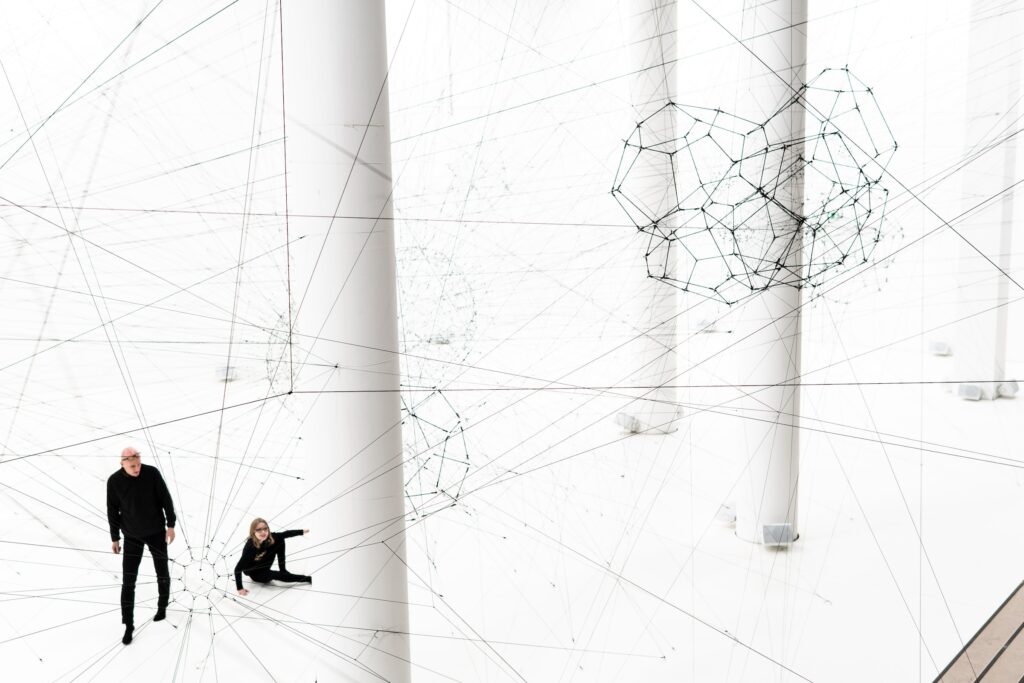 Two people in a large white room surrounded by invisible threat as a metaphor to zero trust model.