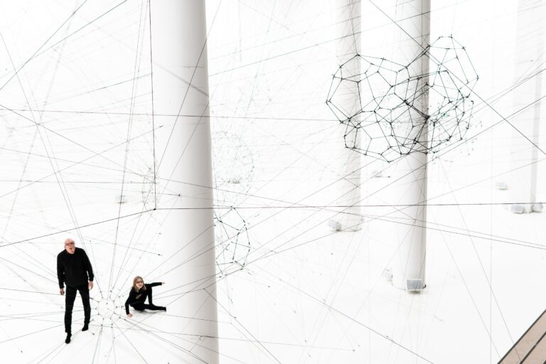 Two people in a large white room surrounded by invisible threat as a metaphor to zero trust model.