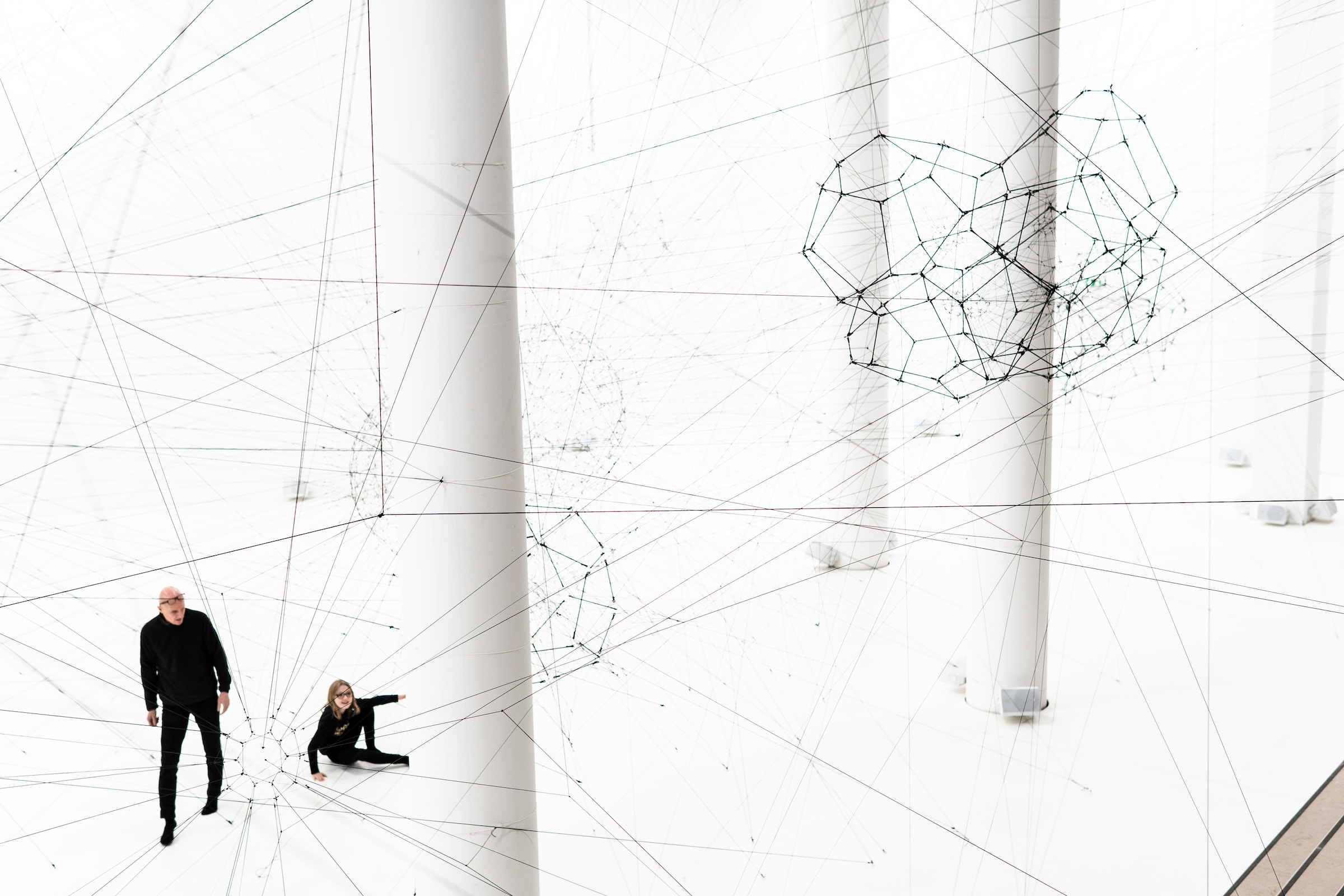 Two people in a large white room surrounded by invisible threat as a metaphor to zero trust model.